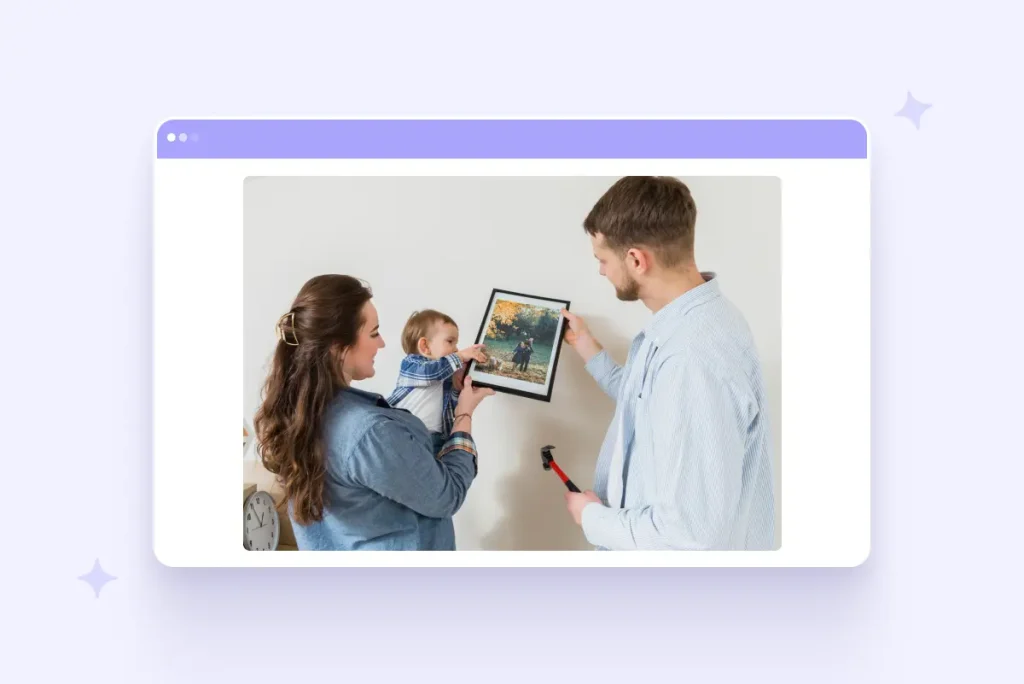 A couple hanging a framed family photo on the wall while holding their baby, illustrating a personalized canvas